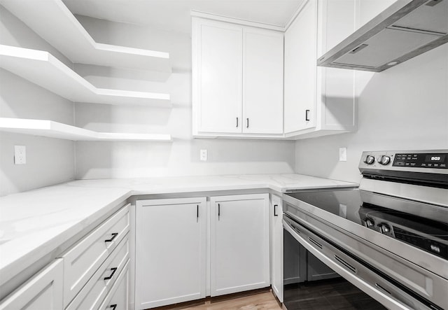 kitchen featuring light stone countertops, under cabinet range hood, open shelves, white cabinetry, and electric range