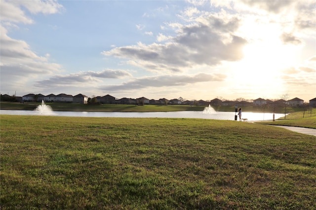 view of yard featuring a residential view and a water view