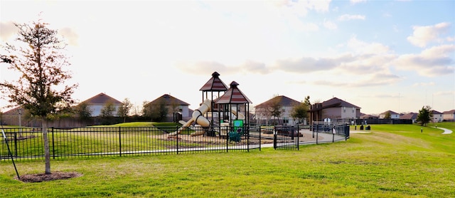 community jungle gym with a yard and fence