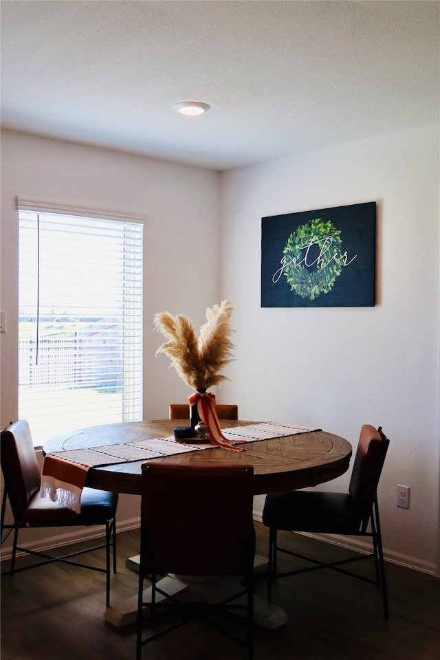 dining area featuring baseboards and dark wood-style flooring