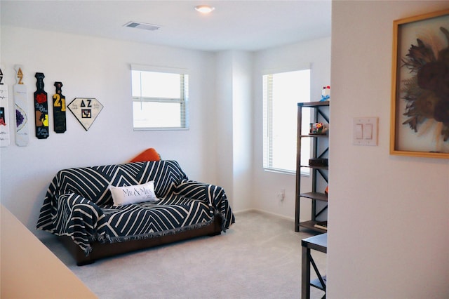 living area with visible vents and carpet floors