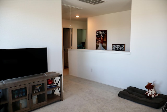 interior space with visible vents, attic access, and carpet flooring