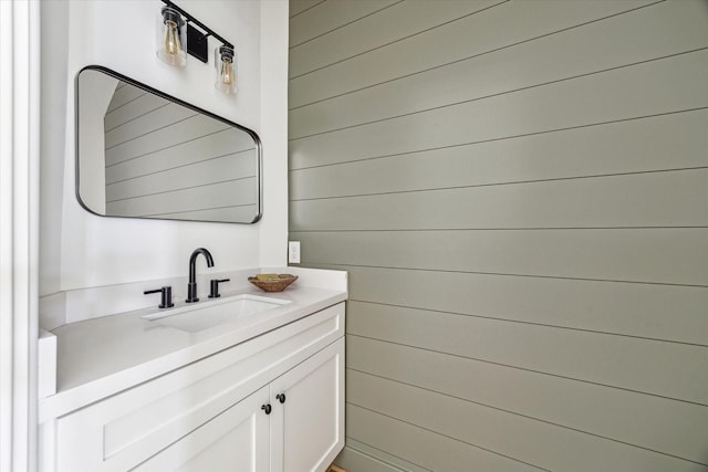 bathroom with vanity and wood walls