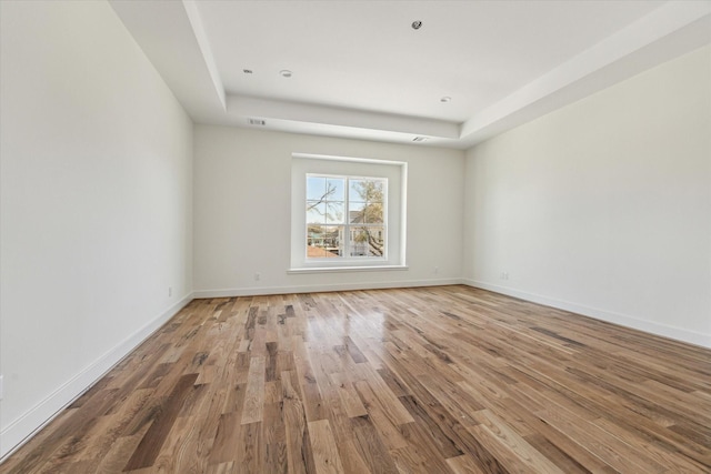 empty room with visible vents, baseboards, and wood finished floors