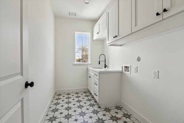 clothes washing area featuring visible vents, washer hookup, a sink, baseboards, and light floors