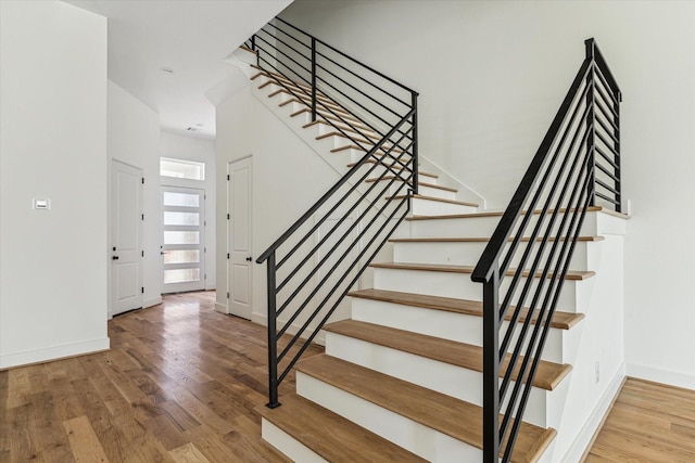 stairs featuring wood finished floors and baseboards