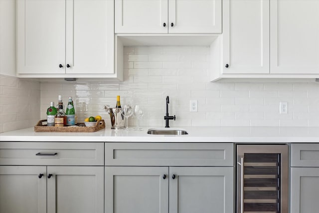 bar featuring indoor wet bar, wine cooler, backsplash, and a sink