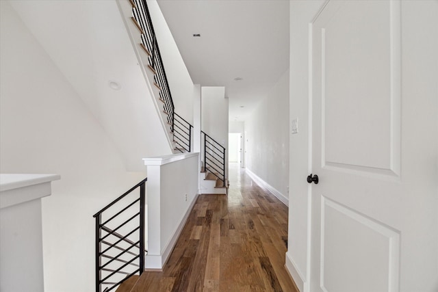 hallway featuring stairs, baseboards, and wood finished floors