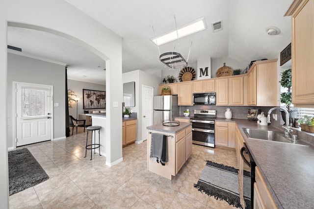 kitchen with light brown cabinets, visible vents, a kitchen island, a sink, and black appliances