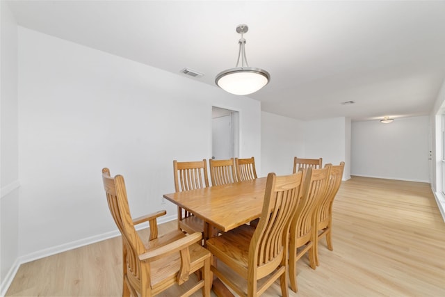 dining room with light wood-style floors, visible vents, and baseboards