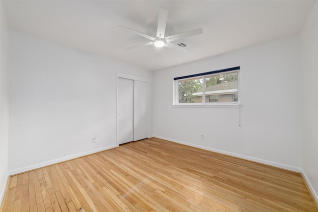 unfurnished bedroom with a closet, light wood-style flooring, baseboards, and ceiling fan