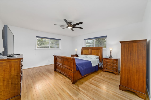 bedroom with light wood-type flooring, baseboards, and a ceiling fan