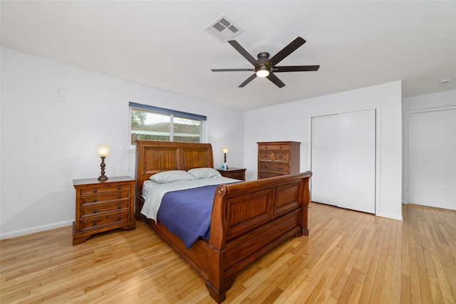 bedroom with visible vents, a ceiling fan, a closet, light wood finished floors, and baseboards