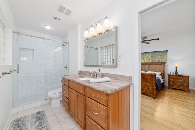 full bathroom with ceiling fan, visible vents, toilet, and a stall shower