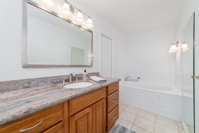 bathroom with tile patterned flooring, vanity, and a garden tub