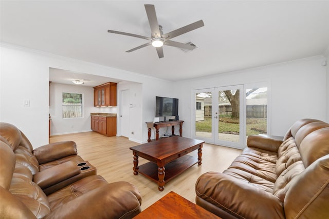 living room with crown molding, baseboards, light wood-type flooring, and ceiling fan