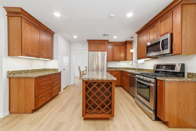 kitchen featuring light stone countertops, visible vents, light wood-style flooring, a sink, and appliances with stainless steel finishes