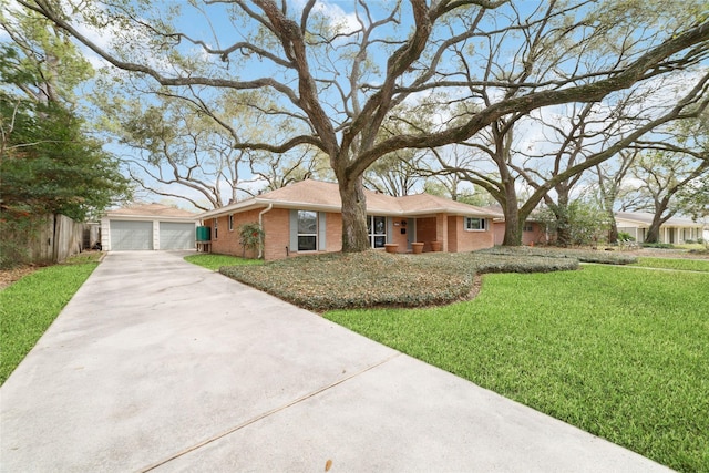 ranch-style home featuring brick siding, fence, a front yard, a garage, and an outbuilding