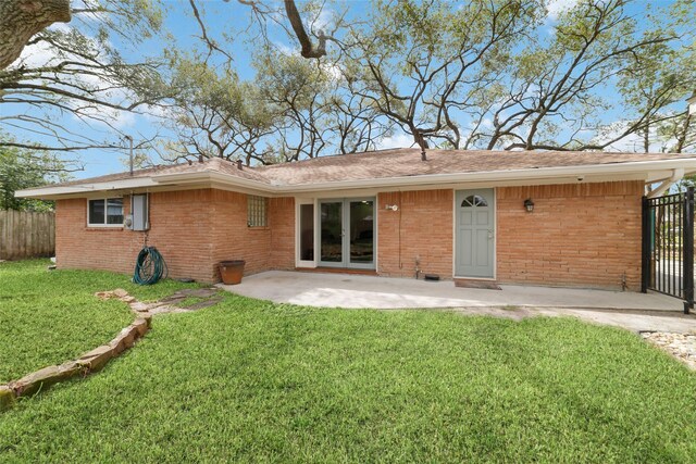 back of house with a patio, fence, french doors, a lawn, and brick siding