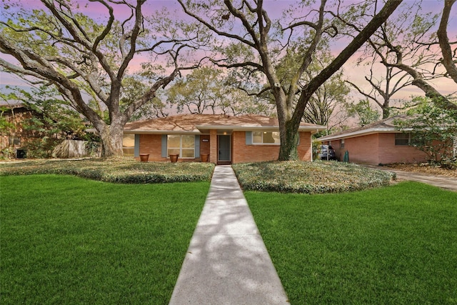 single story home featuring brick siding and a front lawn