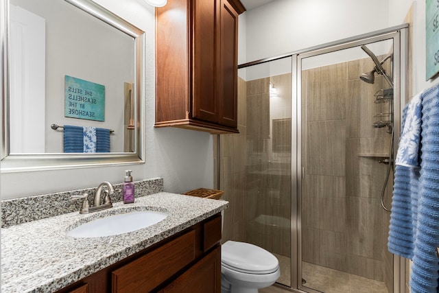 bathroom with vanity, toilet, and a stall shower