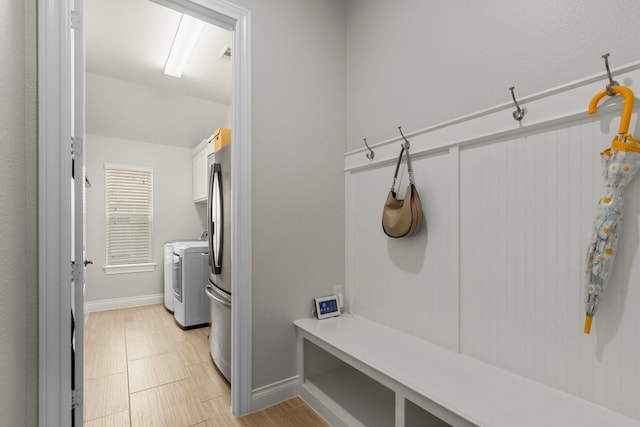 mudroom featuring visible vents, baseboards, and washing machine and clothes dryer