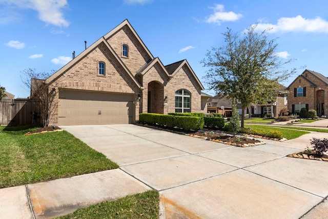 french country home with a front lawn, fence, brick siding, and driveway