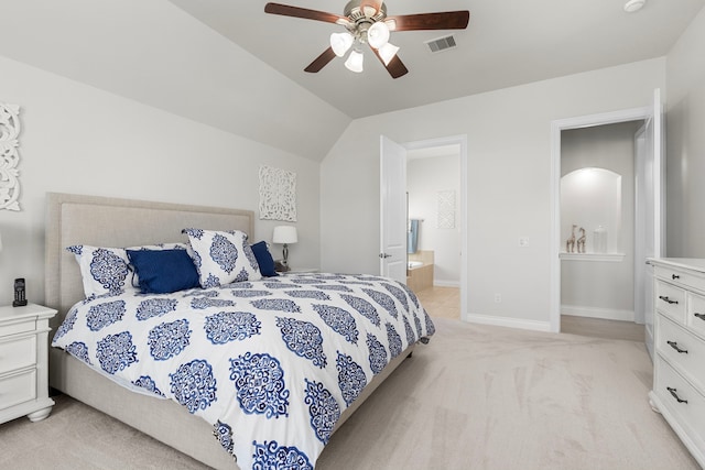 bedroom featuring visible vents, baseboards, lofted ceiling, ensuite bathroom, and light colored carpet