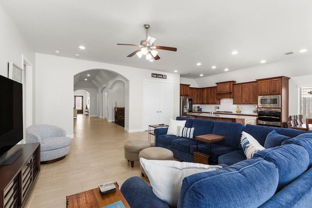 living area with visible vents, ceiling fan, recessed lighting, light wood-style flooring, and arched walkways