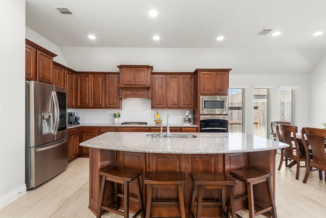 kitchen featuring visible vents, appliances with stainless steel finishes, and vaulted ceiling