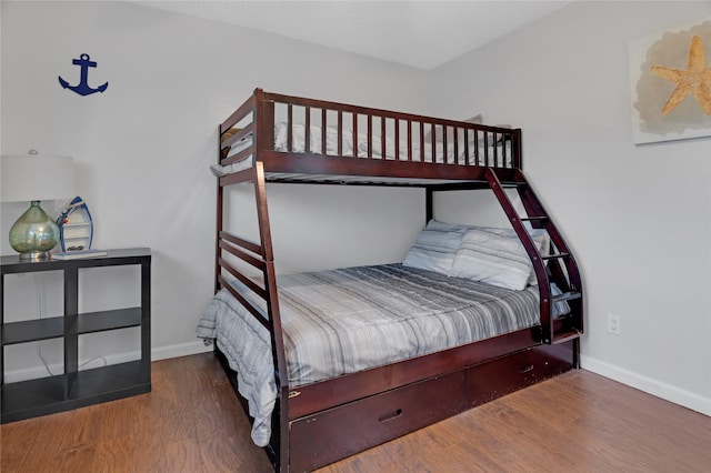 bedroom with wood finished floors and baseboards