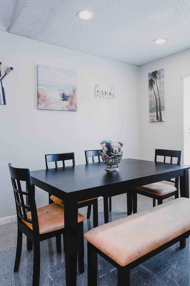 carpeted dining space with recessed lighting, baseboards, and a textured ceiling