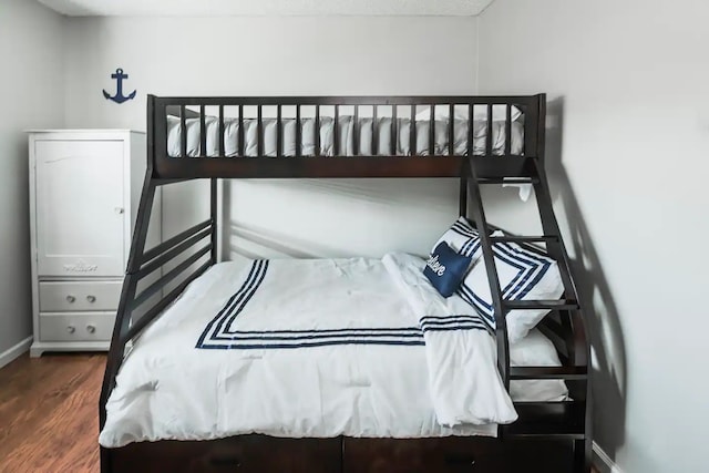 bedroom with baseboards and wood finished floors