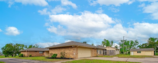 view of front of house featuring brick siding, a garage, concrete driveway, and a front lawn