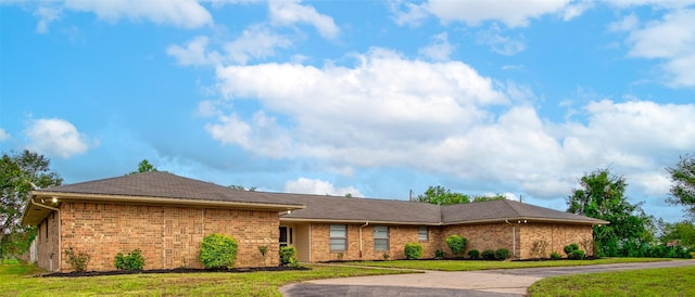 view of front facade featuring brick siding and a front yard