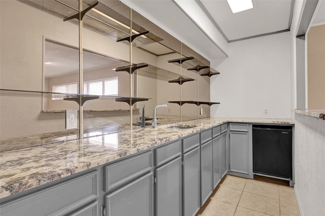 kitchen with light tile patterned floors, a sink, ornamental molding, gray cabinetry, and dishwasher