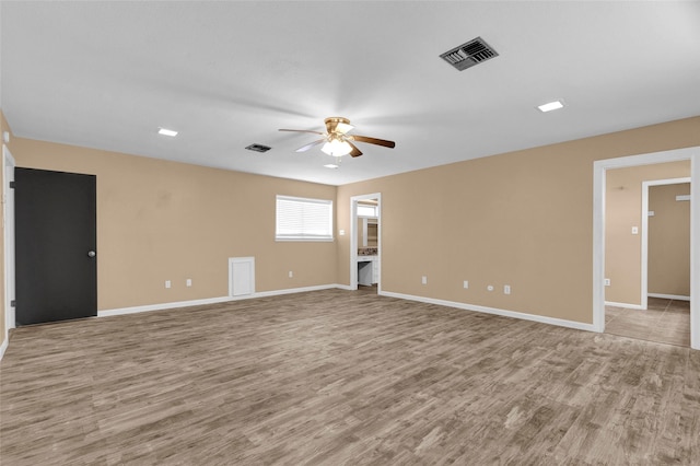 empty room featuring baseboards, wood finished floors, visible vents, and ceiling fan