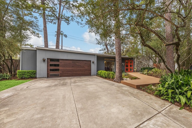 mid-century inspired home featuring driveway, french doors, and a garage