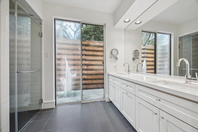 bathroom featuring a sink, double vanity, a stall shower, and tile patterned floors