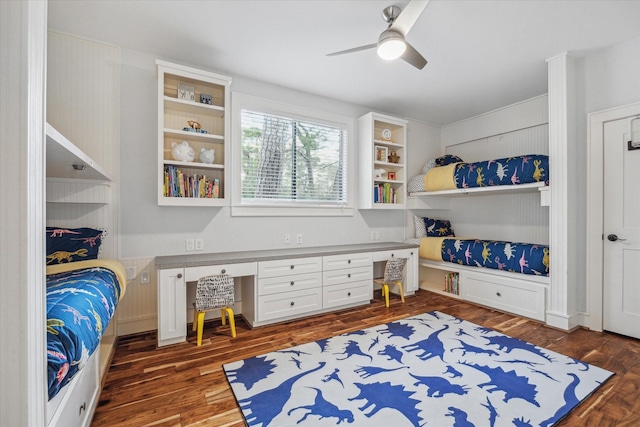 bedroom featuring built in desk, a ceiling fan, and dark wood-style flooring