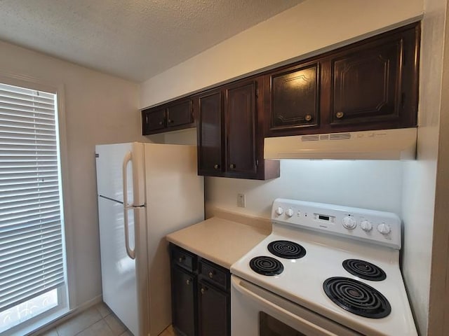 kitchen with under cabinet range hood, a textured ceiling, white appliances, dark brown cabinetry, and light countertops