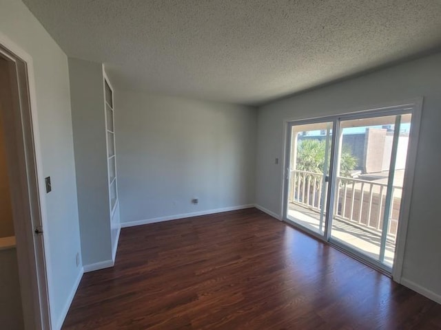 unfurnished room with a textured ceiling, baseboards, and wood finished floors