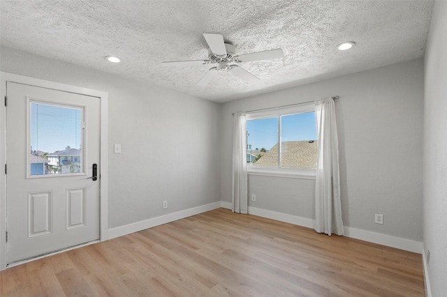 empty room with baseboards, ceiling fan, recessed lighting, light wood-style flooring, and a textured ceiling