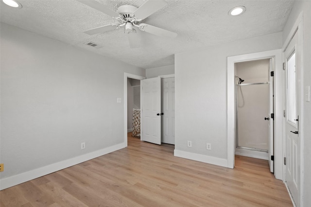 unfurnished bedroom featuring light wood-style flooring, baseboards, visible vents, and a textured ceiling