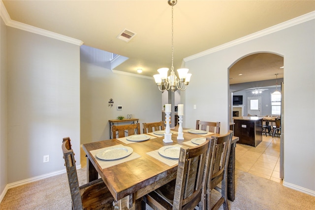 dining space featuring light tile patterned floors, visible vents, arched walkways, and light colored carpet