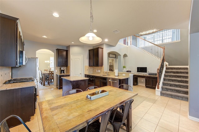 dining room with arched walkways, recessed lighting, stairs, and light tile patterned flooring