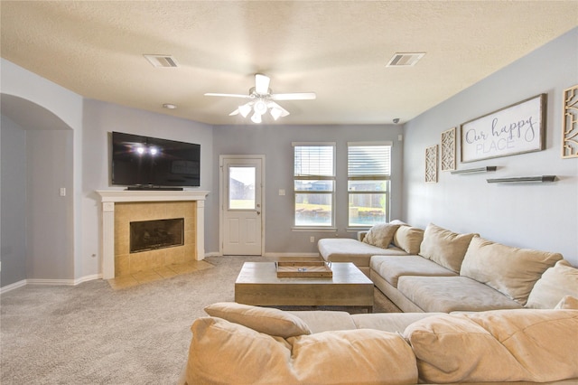 living room with visible vents, carpet flooring, a textured ceiling, and a ceiling fan