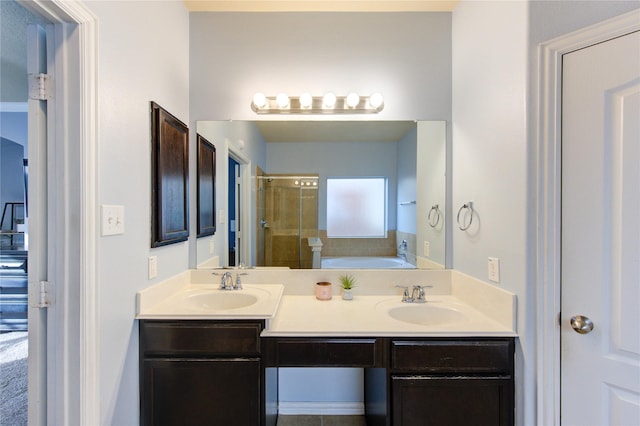 bathroom featuring a shower stall, a bath, double vanity, and a sink