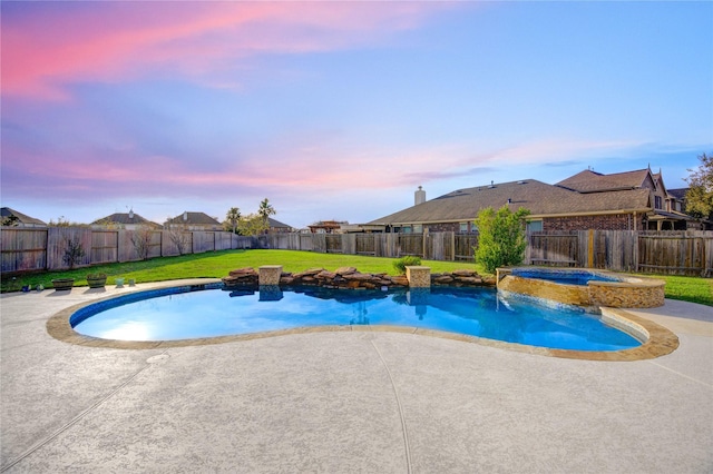 pool at dusk with a yard, a fenced backyard, and a patio area