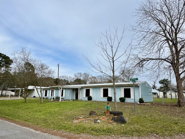 view of front of property with a front lawn, fence, and metal roof